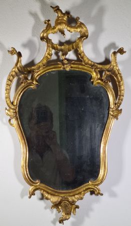 71. Carved and gilded wooden mirror.